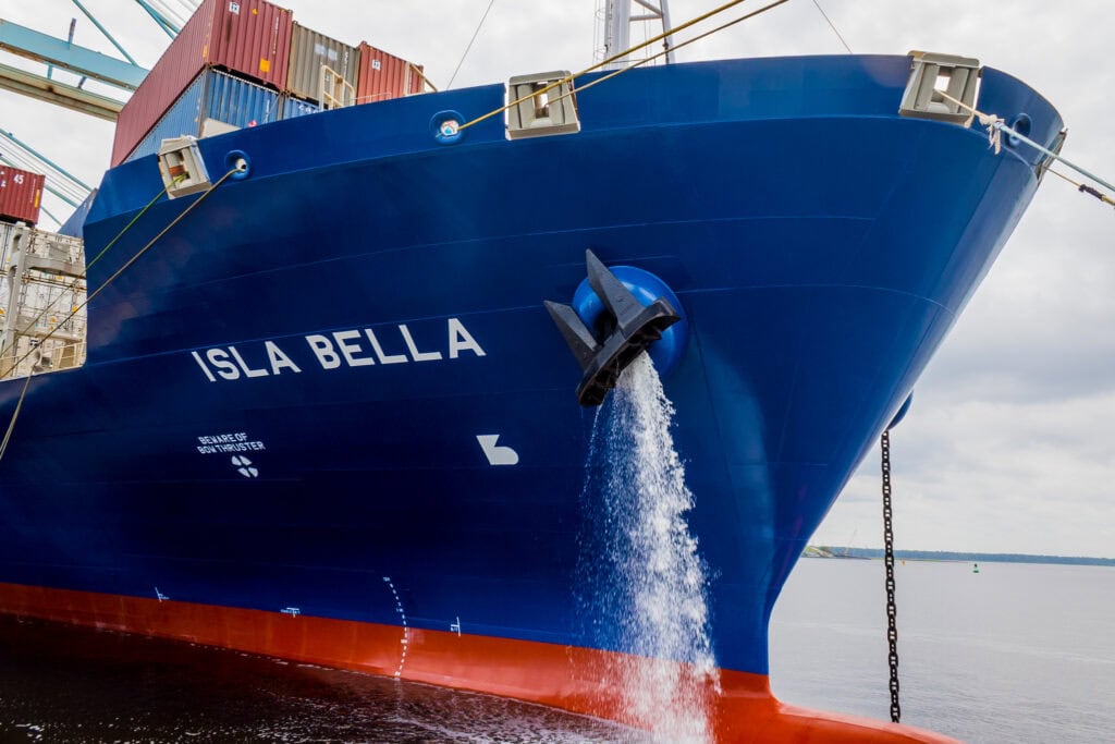 ISLA BELLA cargo ship with water being discharged from the bow.