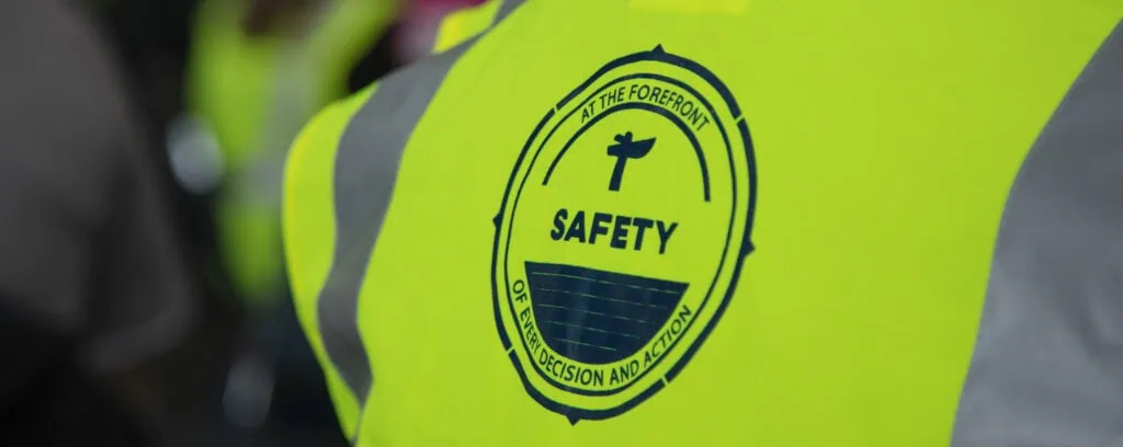 High-visibility safety vest with safety badge logo.