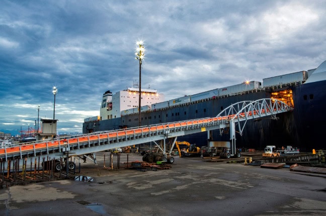 Cargo ship docked at the port with a gangway connecting to the vessel.