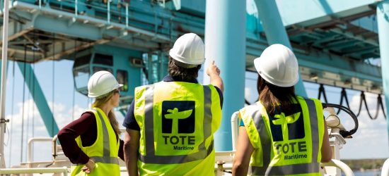 Workers in safety vests and helmets inspecting an offshore platform.