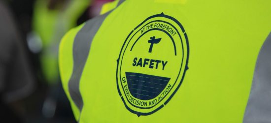 High-visibility safety vest with safety badge logo.