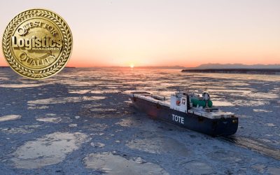 TOTE cargo ship navigating icy waters at sunset.